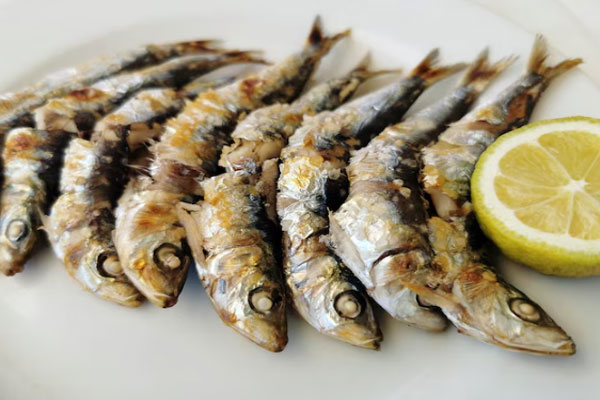 Primer plano de un plato de boquerones con limón típicos de Málaga
