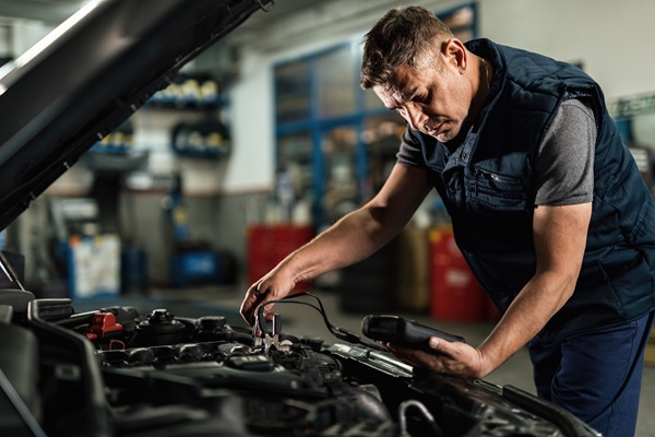 Talleres de mecánica - Mecánico utiliza un probador para diagnosticar la batería de un coche