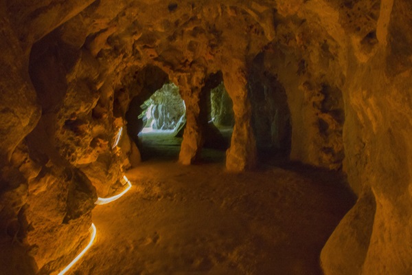 Interior de una cueva de piedra con tres túneles