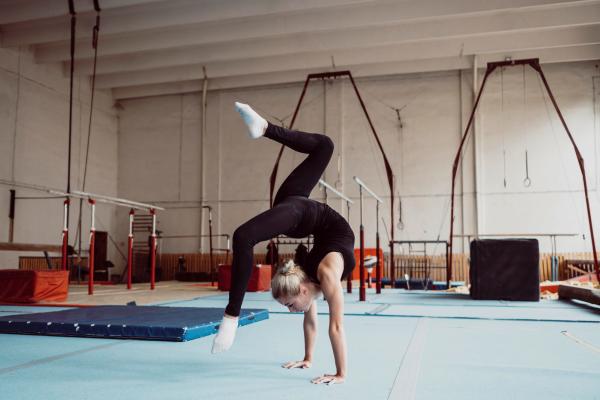 Gimnasia rítmica - Bailarina pone a prueba su flexibilidad corporal mediante una serie de ejercicios en el mejor centro de gimnasia rítmica en Madrid