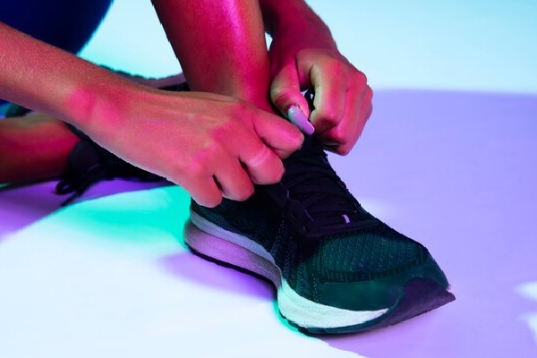 Tiendas de calzado deportivo - Mujer atando sus zapatillas de deporte compradas en las mejores tiendas de calzado deportivo en Madrid