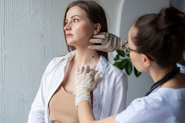 Clínicas dermatológicas de Barcelona - Dermatóloga examina con delicadeza la presencia de un raro lunar en el cuello de una paciente en la mejor clínica estética Barcelona