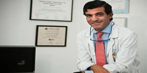Mejores cardiólogos de Madrid - Foto del Dr. José Luis Zamorano, posando frente a sus títulos y reconocimientos como mejor doctor cardiólogo de Madrid
