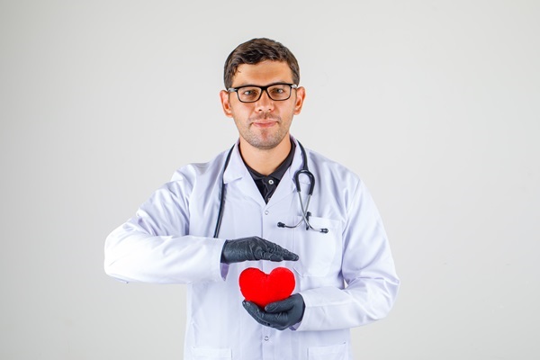 Mejores cardiólogos de Madrid - Doctor con lentes mostrando en sus manos la figura de un corazón