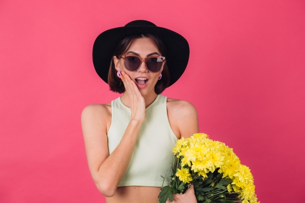 Tendencias primavera verano 2024 - Mujer joven usando sombrero y lentes en tendencia con cara de sorprendida