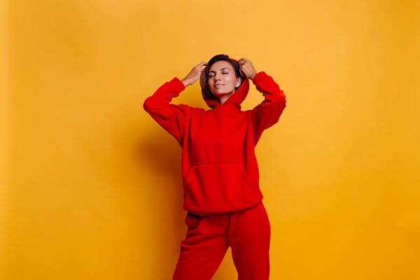 Mujer joven usando un abrigo y pantalón monocromático de color rojo