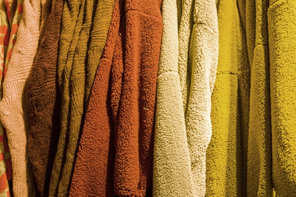 Abrigos de diferentes colores y texturas en un armario