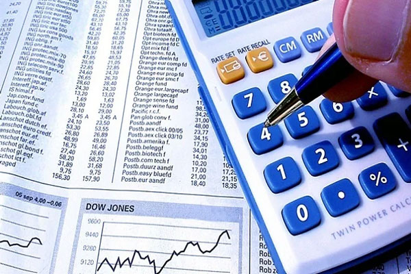 Hombre chequea la rentabilidad de sus ganancias en el mes con la ayuda de una calculadora 