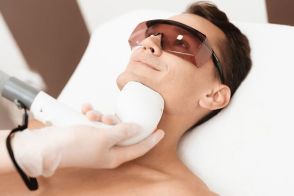 Dermatólogo aplica un tratamiento estético para refrescar y revitalizar el rostro de un paciente masculino 