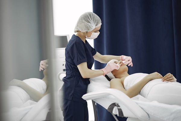Clínicas estéticas mejor valoradas de Madrid - Médico especialista realizando un tratamiento facial a una mujer en la mejor clínica estética Madrid