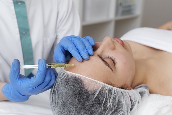 Clínicas estéticas mejor valoradas de Madrid - Esteticista aplicando una inyección en el rostro de una mujer joven en una de las mejores clínicas estéticas Madrid