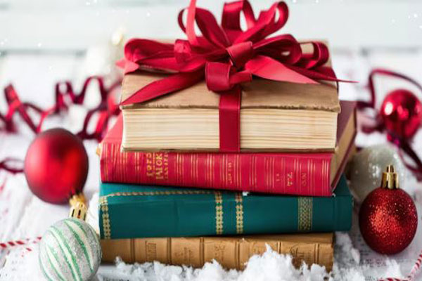 Regalos de navidad - Libros con lazo como parte de un obsequio navideño para estimular la lectura 