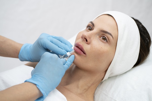 Mejores clínicas estéticas Madrid - Médico especialista realizando un aumento de labios a una mujer joven con ácido hialurónico Madrid