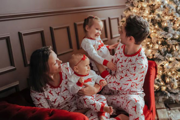 Familia con pijamas navideñas de reno disfrutan de la Nochebuena en casa y con amor 