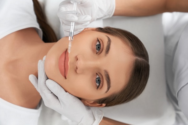 Mejor clínica ácido hialurónico Barcelona - Médico estético aplicando un tratamiento con ácido hialurónico en los labios de una mujer