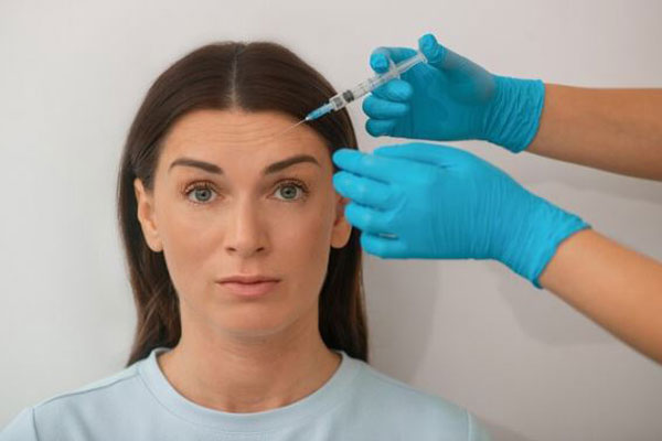 Bótox y ácido hialurónico - Mujer Joven con arrugas en la frente recibe inyecciones de toxina botulínica en la mejor clínica ácido hialurónico Madrid