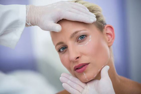 Bótox y ácido hialurónico - Dermatólogo examina el rostro de una mujer previo a un tratamiento facial con ácido hialurónico Madrid