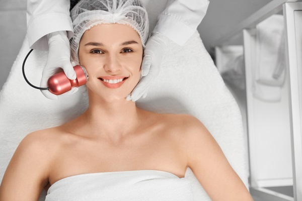 Médico especialista realizando un tratamiento de rejuvenecimiento facial a una mujer