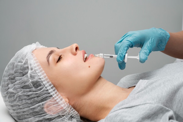 Tratamientos estéticos - Médico especialista aplicando una inyección de ácido hialurónico Madrid en los labios de una mujer