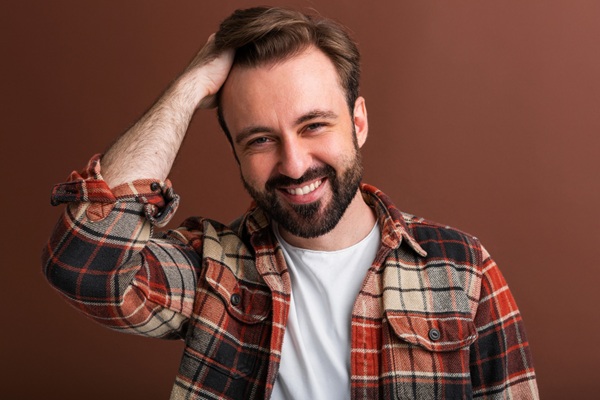 Hombre feliz con un cabello natural y abundante luego de un implante capilar Turquía