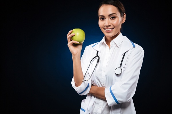 Nutricionistas deportivos Barcelona - Nutricionista deportivo sosteniendo una fruta como parte del programa de nutrición deportiva en Barcelona