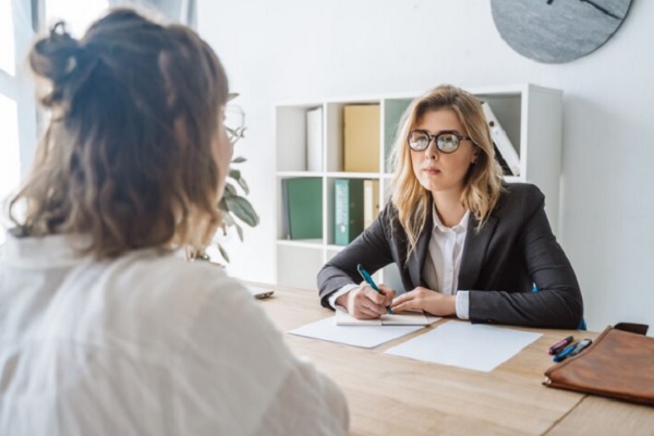 entrevistadora haciendo preguntas a chica que solicita una oferta de empleo