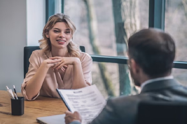 preguntas frecuentes en una entrevista de trabajo- mujer sonriendo en entrevista de trabajo