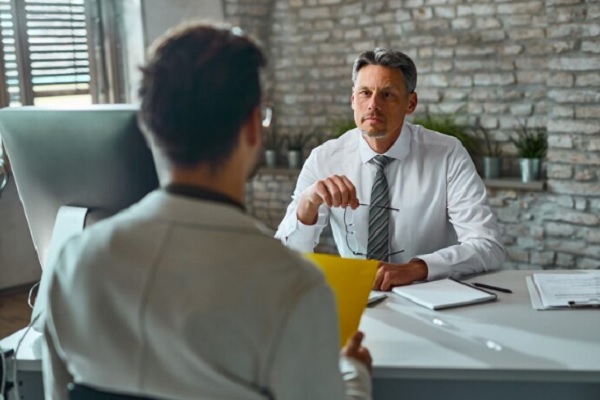 preguntas frecuentes en una entrevista de trabajo- hombre entregando sobre con CV a reclutador